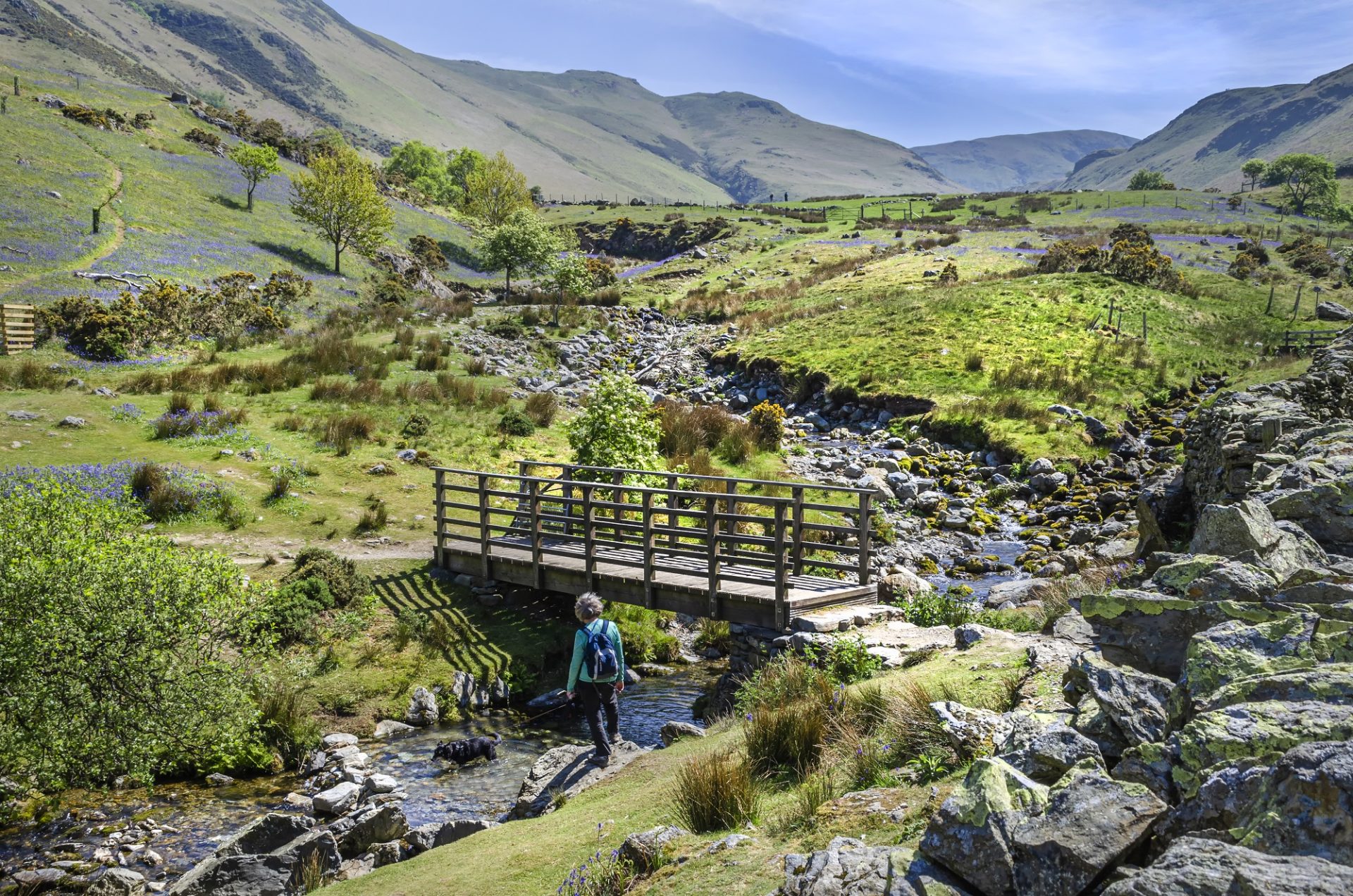 A Hiker Taking A Brake By The Stream Whiles Walking The Hills In