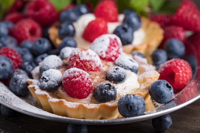 Dessert Tarts With Raspberries And Blueberries On A Wooden Table