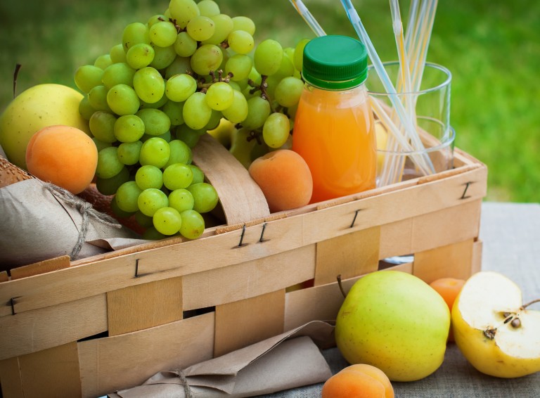 Picnic Basket Yellow Orange Green Fruits on Grass Background Summer Time Selective focus