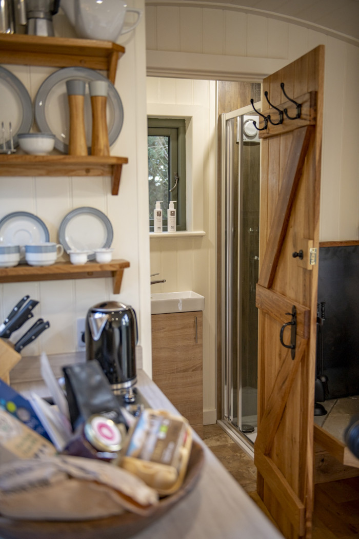 kitchen and door leading to ensuite shower room in elm retreat shepherds hut