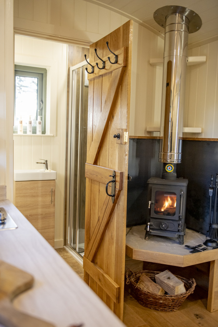 kitchen area with log burning cast iron stove and door to ensuite shower room